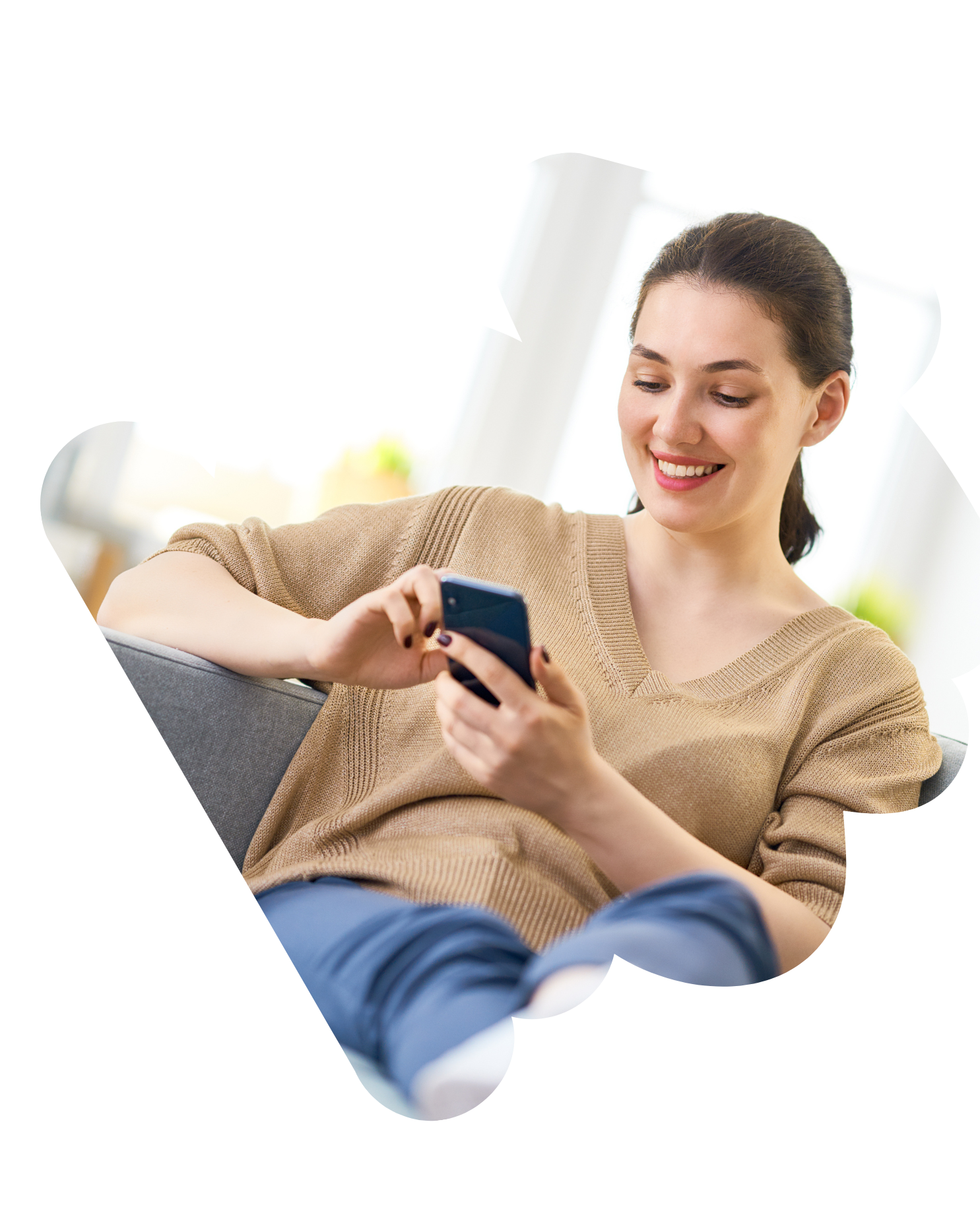 Smiling woman relaxing on a couch looking at her phone